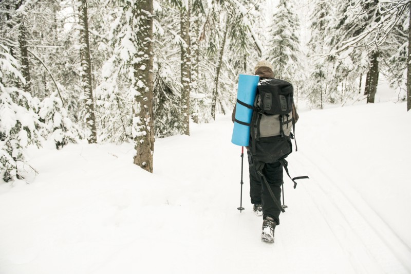 Caucasian hiker walking in snowy forest