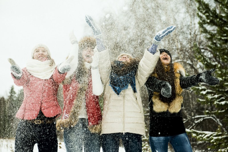 Caucasian girls tossing snow in air