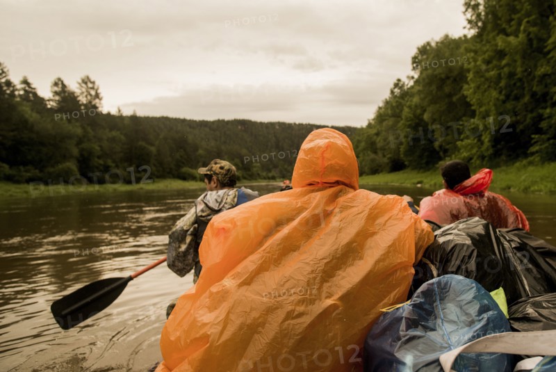 People wearing ponchos on boat in river