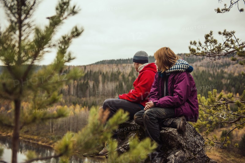 Friends sitting on rock on remote hillside