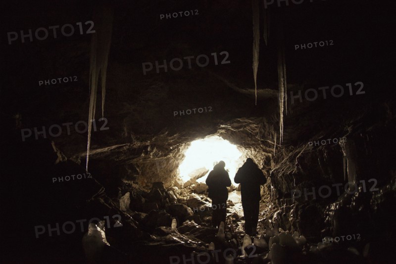 Caucasian hikers exploring cave