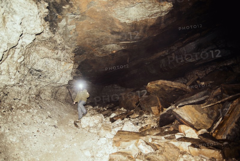 Caucasian hiker wearing headlamp in cave