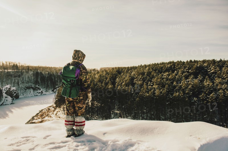 Caucasian hiker standing on snowy hilltop