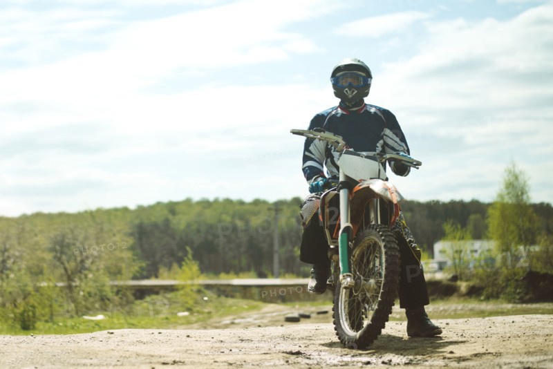 Caucasian man riding dirt bike in field