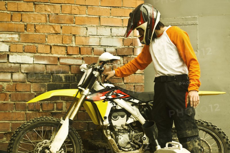 Caucasian man examining dirt bike