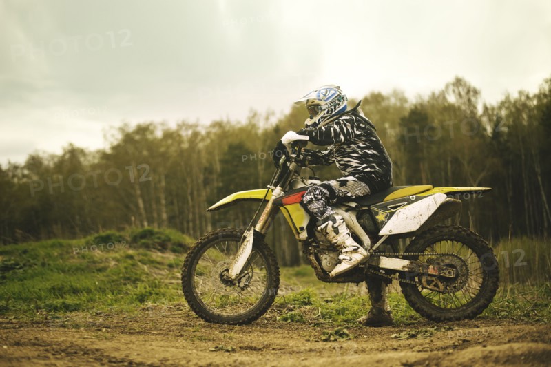 Caucasian man riding dirt bike in field