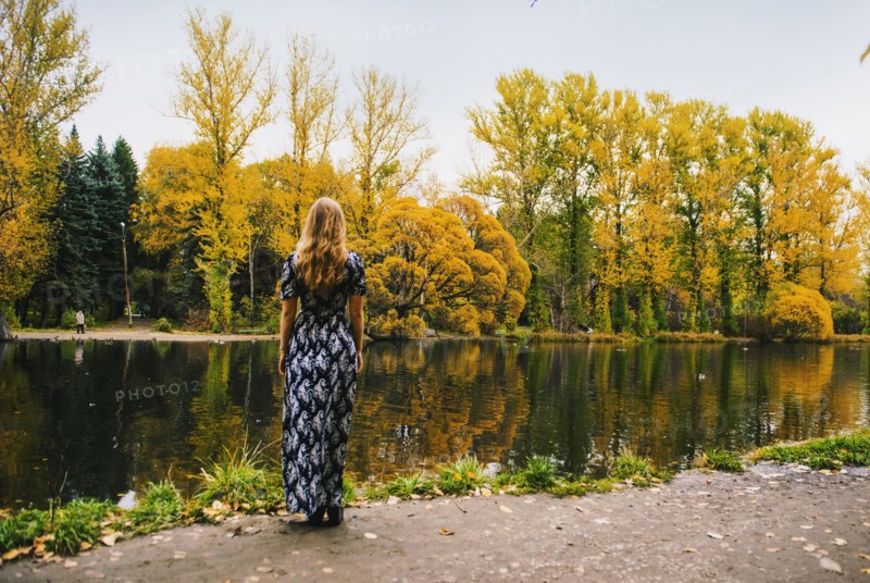 Caucasian woman admiring pond in park