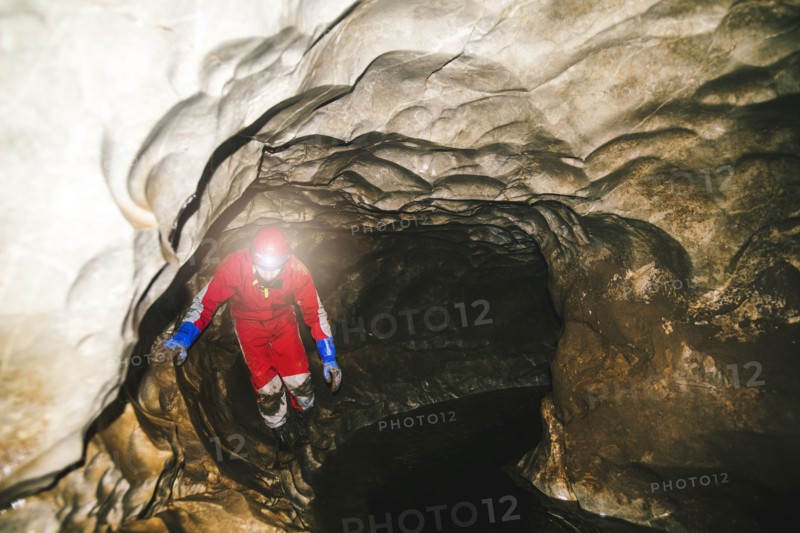 Caucasian hiker wearing headlamp in cave