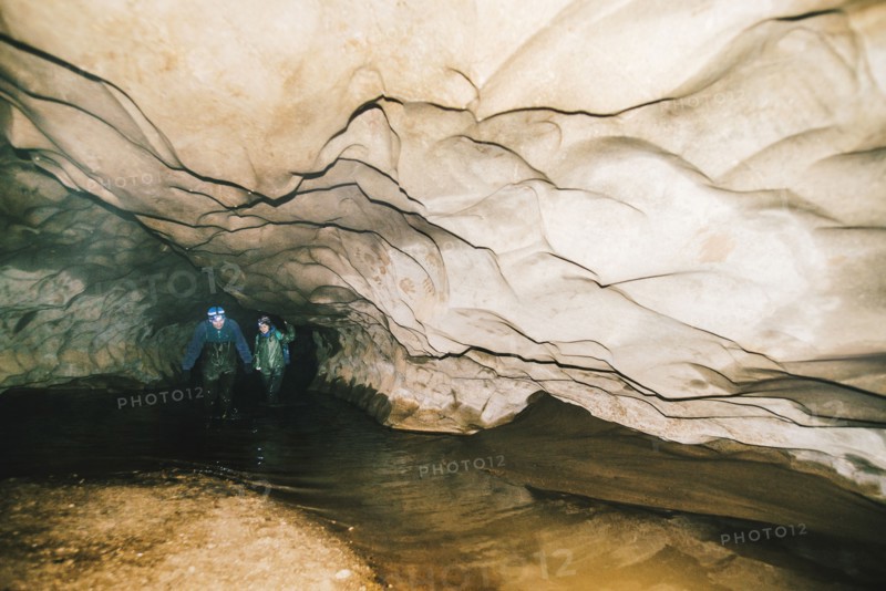 Caucasian hikers exploring cave