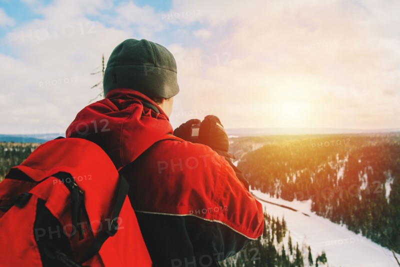 Hiker photographing remote landscape from mountain