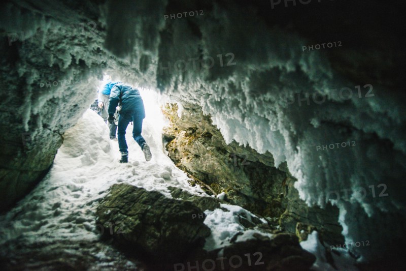 Caucasian hiker walking in icy cave