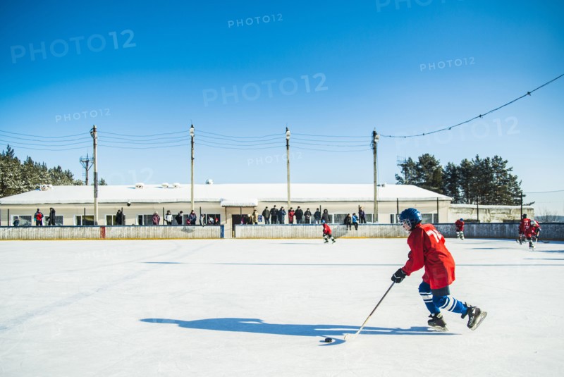 Caucasian boys playing ice hockey outdoors