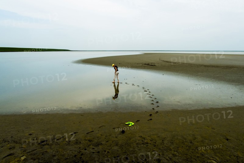 Footprints of woman wading at beach