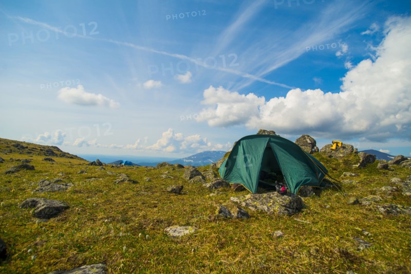 Green tent on rocky mountain