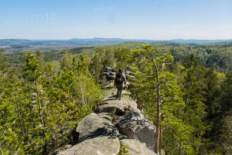 Caucasian man walking on mountain rock admiring scenic view