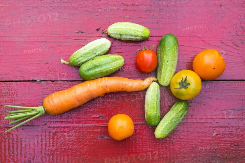 Close up of fresh vegetables on red wooden table