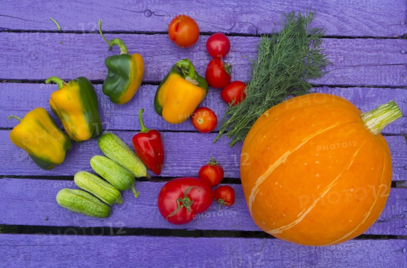 Fresh vegetables on purple wooden table