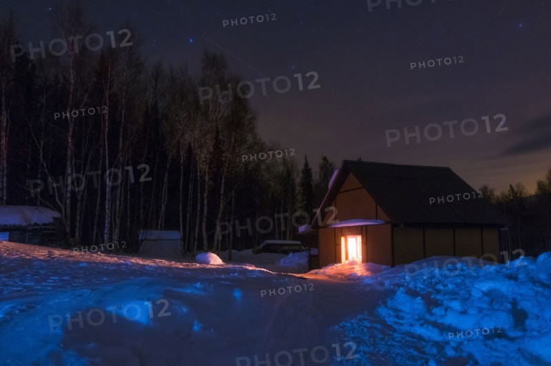 Light glowing in remote cabin in winter