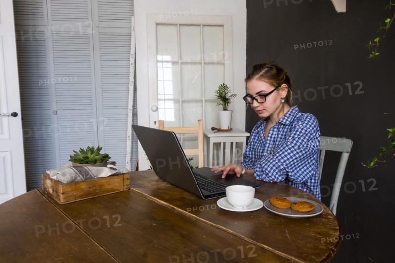 Caucasian woman sitting at table using laptop