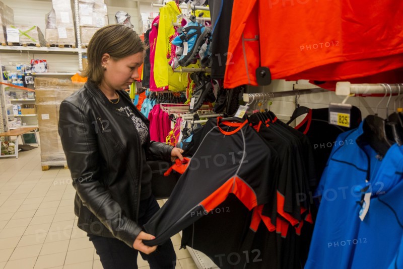 Caucasian woman examining shirt in store