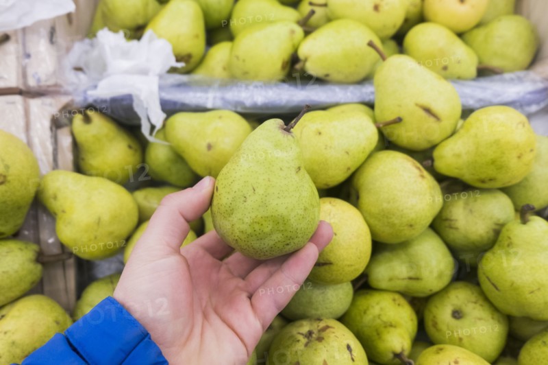 Hand holding green pear