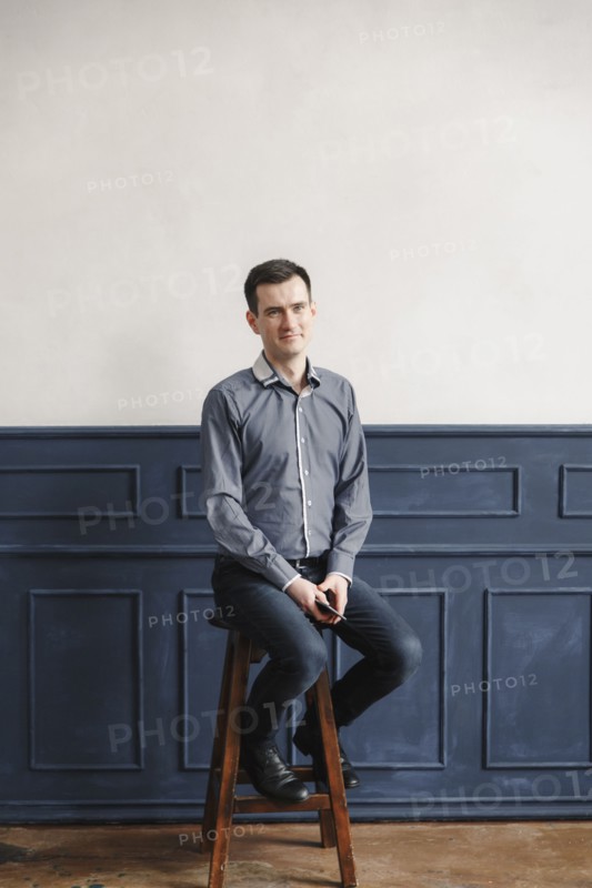Portrait of Middle Eastern man sitting on stool