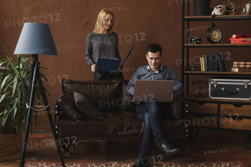 Middle Eastern couple using laptop in livingroom