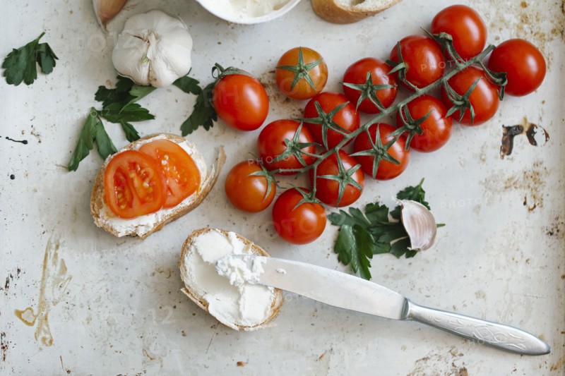 Tomatoes on vine near cream cheese and bread