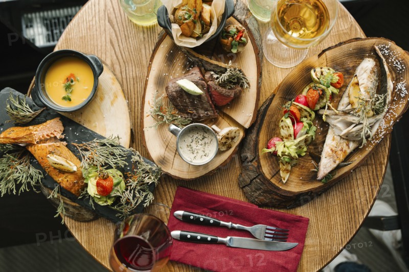 Variety of meat and fish on table with wine