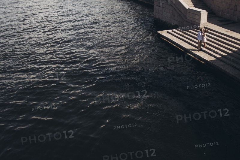 Middle Eastern couple standing on waterfront staircase