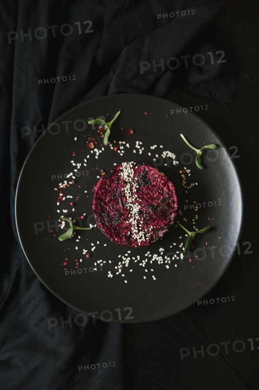 Sesame seeds and garnish on red food on plate