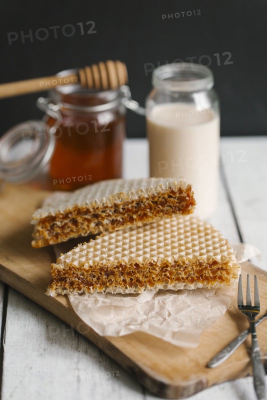 Dessert on cutting board with milk and honey