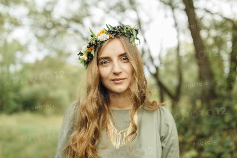 Middle Eastern woman wearing flower crown in woods