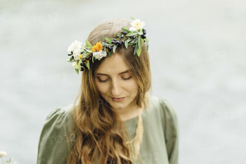 Middle Eastern woman wearing flower crown looking down