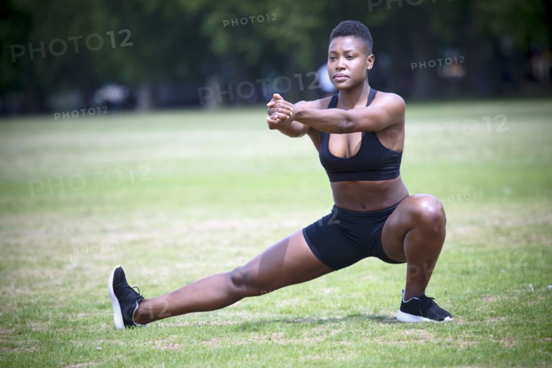 Black athlete stretching in park