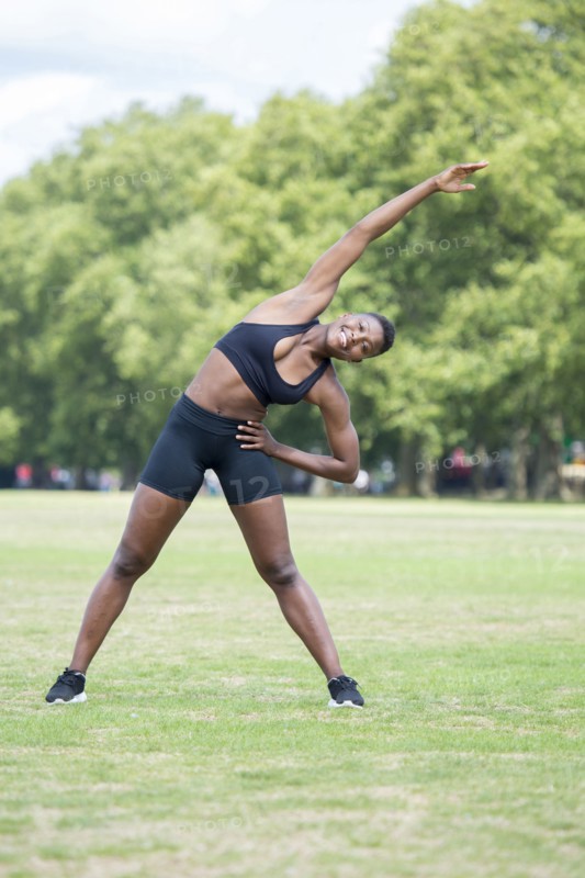 Black athlete stretching in park
