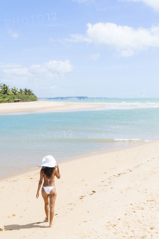 Mixed race woman walking on beach