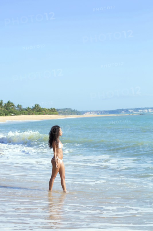 Mixed race woman walking on beach