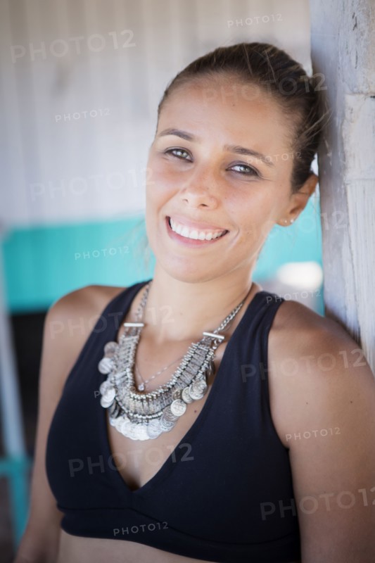 Smiling hispanic woman wearing necklace and bikini