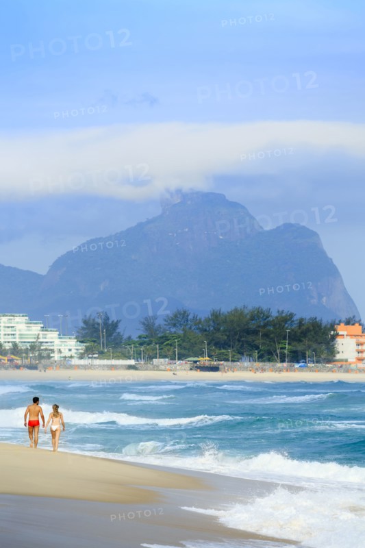 Couple walking on beach near waves