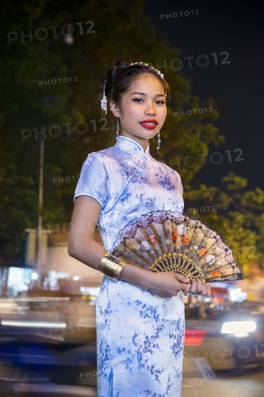 Portrait of Asian woman wearing traditional clothing holding fan