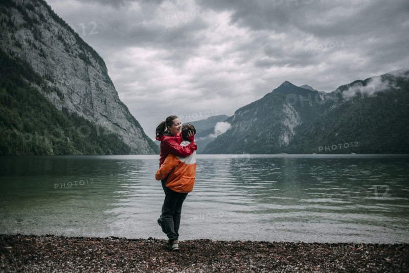Caucasian man hugging near mountain lake