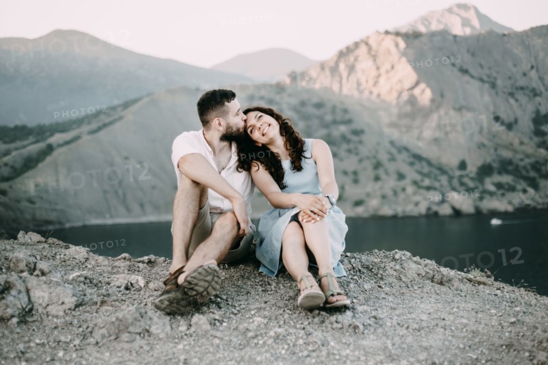 Caucasian man kissing woman on forehead at lake