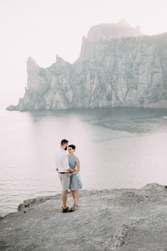 Caucasian man hugging woman at beach
