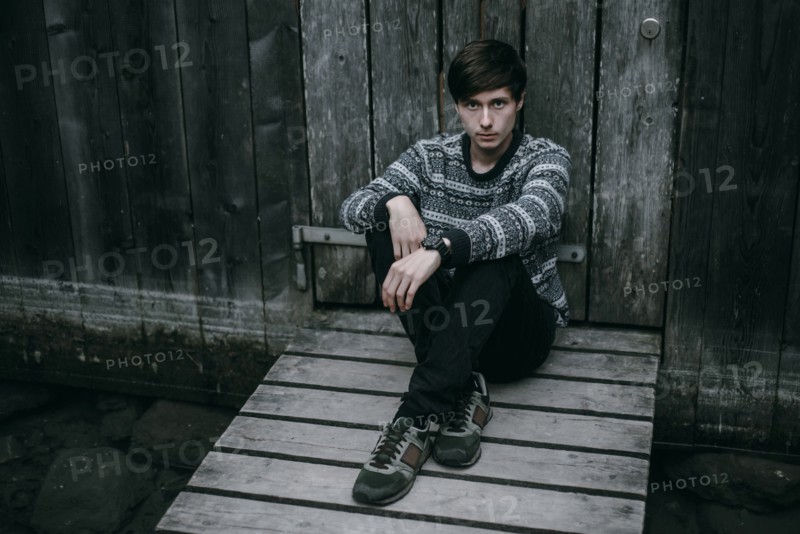 Caucasian man sitting on wooden dock