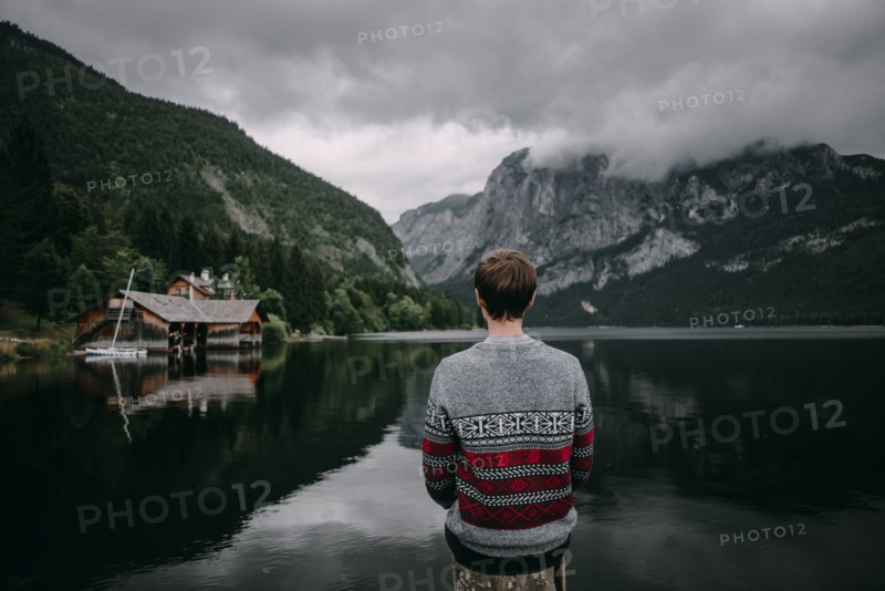 Caucasian man sitting on post admiring scenic view of mountain