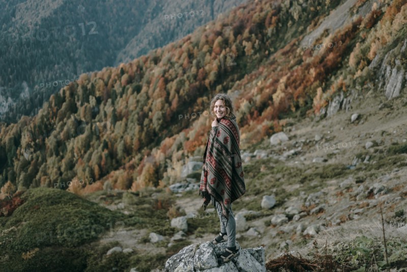 Caucasian woman smiling on mountain overlooking valley
