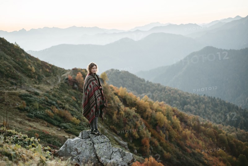 Caucasian woman standing on mountain rock overlooking valley