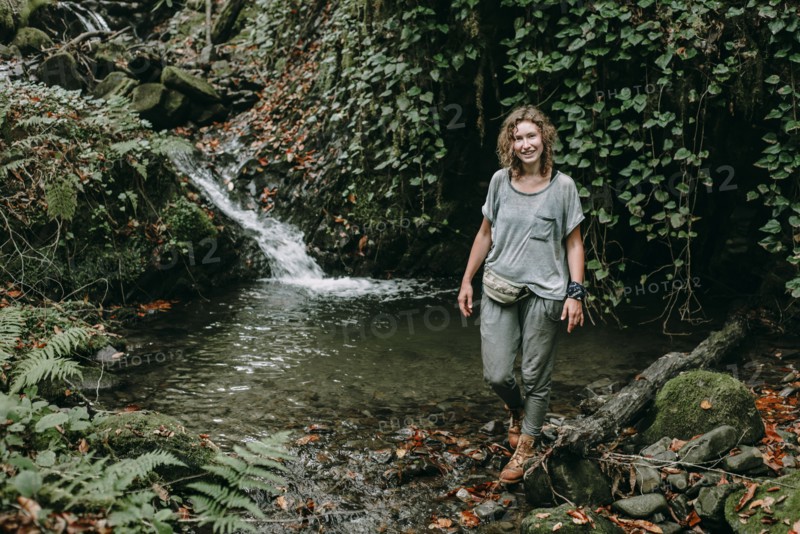 Caucasian woman standing near forest stream