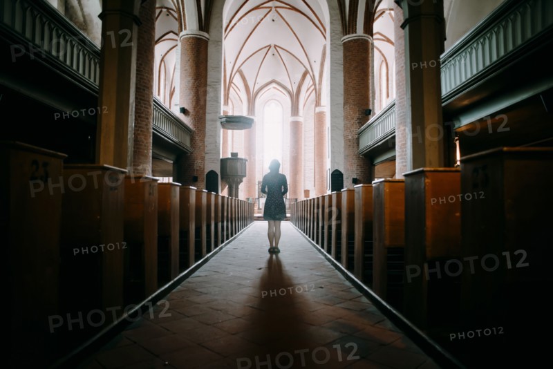 Caucasian woman standing in aisle of church
